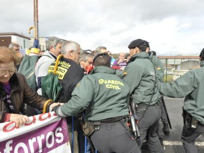 Guardias civiles forcejean con manifestantes para que no traspasen las vallas ante el congreso del PP de Pontevedra, en Silleda.