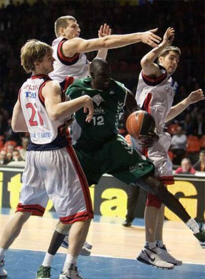 Ndong, <i>pívot</i> del Unicaja, intenta capturar un rebote entre Splitter, Teletovic y Vidal, del Tau.