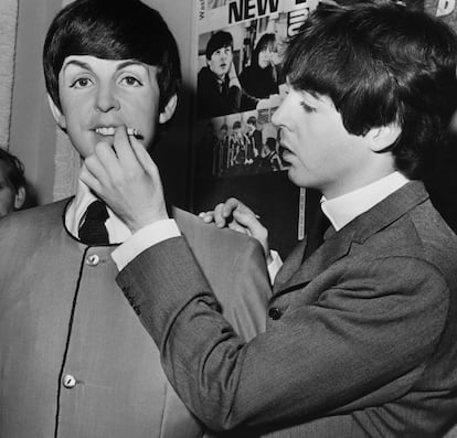 Paul McCartney le pone un cigarrillo a su estatua de cera en el Tussauds Museum de Londres en los años sesenta. 