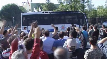 La multitud coreja consignes a soldats arrestats dins d'un autocar.