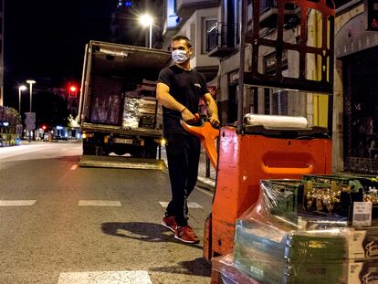 Un transportista descarga alimentos para un comercio del centro de Girona.