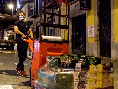 Un transportista descarga alimentos para un comercio del centro de Girona, durante el toque de queda, el pasado domingo.