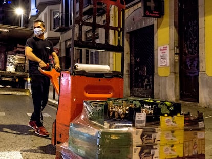 Un transportista descarga alimentos para un comercio del centro de Girona, durante el toque de queda, el pasado domingo.