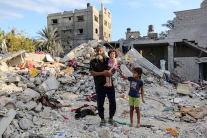 Palestinos fotografiados entre los escombros de los edificios derruidos, en Jan Yunis, este lunes.  