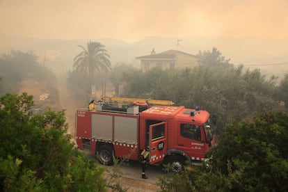 Tareas de extinción en la localidad de Xerta frente a una casa con vecinos confinados dentro.