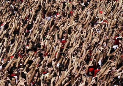 Cientos de personas alzan sus brazos al son de la música de los gaiteros que actúan desde la Casa Consistorial de Pamplona, tras el chupinazo.