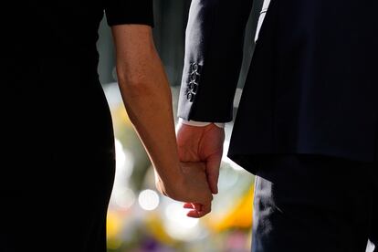 The Duke and Duchess of Sussex hold hands. 