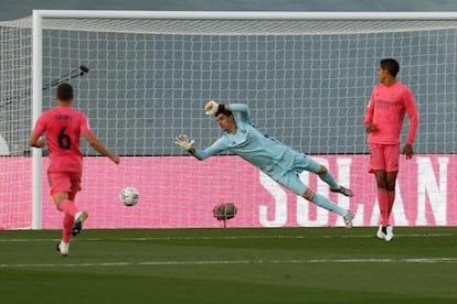 El portero del Real Madrid Courtois trata de detener el lanzamiento de Lozano, del Cádiz, durante el partido.