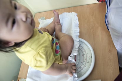 Un niño con problemas de crecimiento es pesado en el centro de salud de Nalaikh.