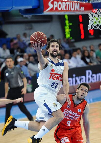 El base español del Real Madrid Sergio Llull entra a canasta ante el base belga del Valencia Basket, Sam Van Rossom.