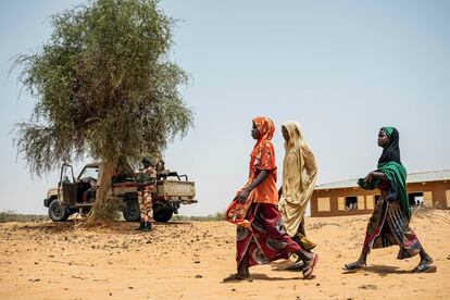 Tres niñas pasan junto a una patrulla de la Guardia Nacional de Níger en el pueblo de Inizdan, en el norte de Tillabéri, escenario de frecuentes ataques yihadistas.
