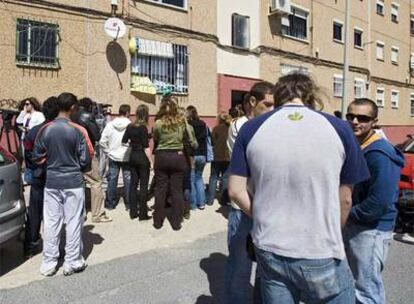 Vecinos y periodistas junto a la vivienda de la barriada de Huelva donde residía el vecino de Mari Luz Cortés.