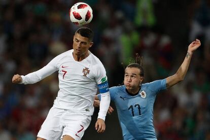 Cristiano Ronaldo (i) golpea el esférico ante la presión de Diego Laxalt.