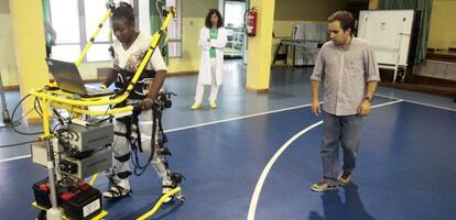 Eloy Urendes, del CSIC, da indicaciones a una paciente parapléjica que utiliza un prototipo de exoesqueleto.