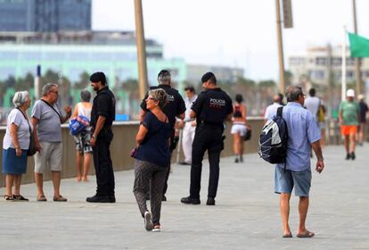 Agents dels Mossos d'Esquadra patrullen pel passeig marítim de Barcelona.