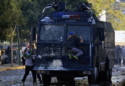 Manifestantes atacan un cañón de agua durante la protesta en Caracas.