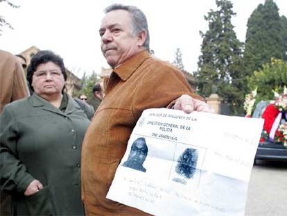 Conocidos de la víctima muestran una foto, suministrada por la policía, del hombre fugado.