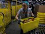 A worker moves a bin filled with products inside of an Amazon fulfillment centre in Robbinsville, New Jersey, U.S., November 27, 2017. REUTERS/Lucas Jackson