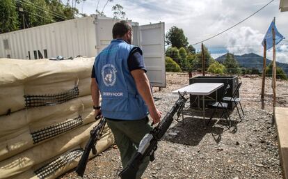Un observador de Naciones Unidas carga armas entregadas por guerrilleros de las FARC, un avance crucial en el proceso de paz con el Gobierno colombiano.