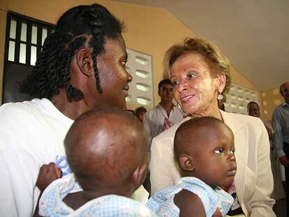 Fernández De la Vega, con los bebés Oader y Oudur, y la madre de éstos, en el barrio haitiano de Cité Soleil.