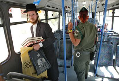 Un judío ultraortodoxo y una policía israelí viajan a bordo de un autobús casi vacío en Jerusalén.