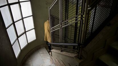 Una mujer baja las escaleras de un edificio histórico en el centro de Ourense.