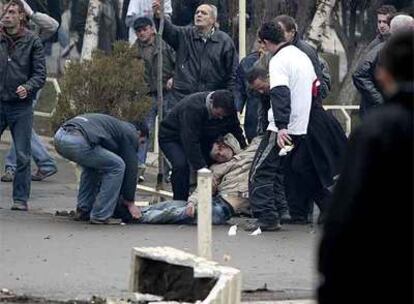 Manifestantes independentistas recogen a un herido en los choques con la policía ayer en Pristina.