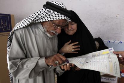 Un matrimonio iraquí estudia la papeleta antes de votar en Basora (sur de Irak).