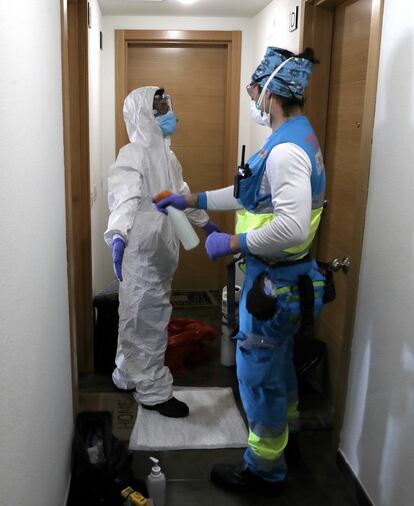Andrés desinfecta a la enfermera Vanesa Jiménez tras haber estado en la casa de un enfermo de coronavirus, en Alcorcón, Madrid.