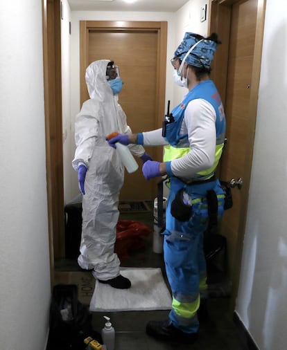 Andrés disinfects the nurse Vanesa Jiménez after visiting a coronavirus patient.