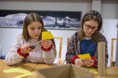 Dos niñas preparan sus telescopios siguiendo el manual de Urban Eriksson.