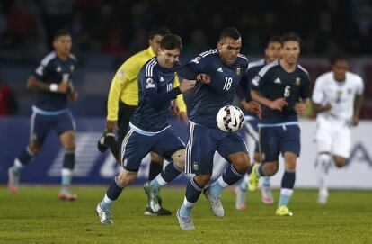 Carlos Tevez conduce el balón con Leo Messi detrás.