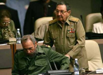 Raúl Castro (de pie) ayuda a su hermano Fidel a sentarse en la Asamblea Nacional cubana en La Habana, en una foto de diciembre de 2004.