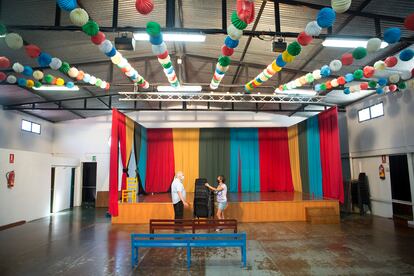 Dos personas preparan una de las casetas de feria de Torremolinos para convertirse en aula escolar.