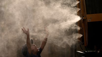 Un niño se refresca con vapor de agua en Kansas City (EE UU) este mes de junio.