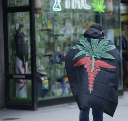 Un activista junto a una tienda que vende marihuana en Canadá.