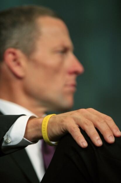 Armstrong exhibe una pulsera de su fundación, 'Livestrong'.