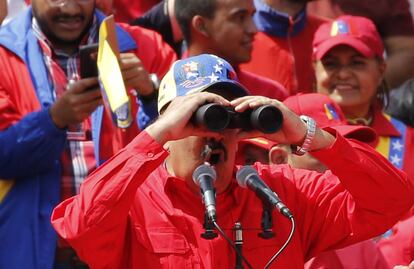 Nicolás Maduro mira a través de unos binoculares durante la celebración del 20° aniversario de la llegada de su predecesor, Hugo Chávez, al poder.