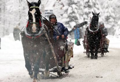 Varios trineos recorren una calle durante una fuerte nevada en Zakopane (Polonia).