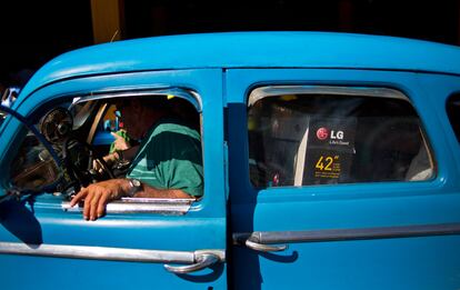 Un taxista transporta un televisor que un viajero se ha traído de Estados Unidos, al salir del aeropuerto Internacional José Marti en La Habana (Cuba).