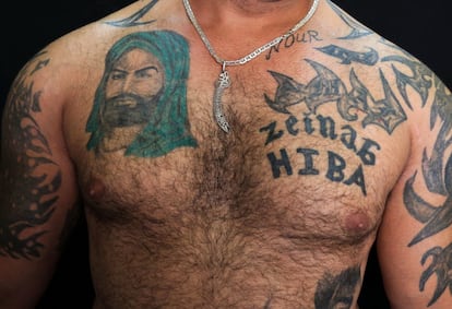 Zulfiqar, 30 años, muestra su tatuaje religioso chiíta donde aparece el primer Imam Ali, a la izquierda, en el suburbio al sur de Beirut, en el Líbano. 