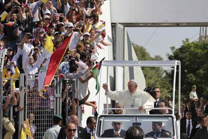 Francisco saluda desde el papam&oacute;vil a la gente que le esperaba en el estadio de Amman para asistir a la misa multitudinaria. 