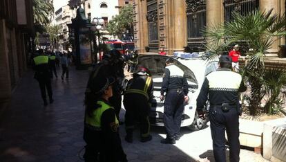 Los bomberos inspeccionan el coche patrulla.