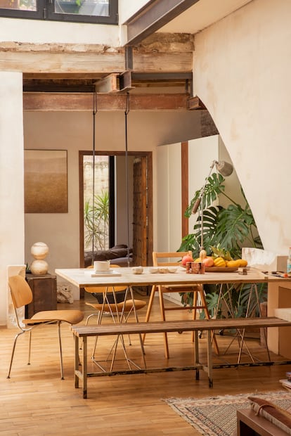 Comedor con banco de madera y hierro procedente de un gimnasio, sillas LCM Eames de Vitra, pieza Jupiter 2 de Turbina, lámpara de pie médicade la Seguridad  Social y cuadro de Véronique Pignat (madre de Mateo).