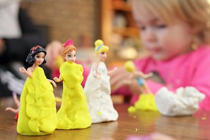 Una niña juega con plastilina en su habitación.