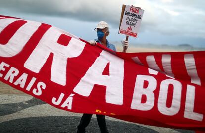 Un manifestante con una mascarilla lleva una pancarta que pida la salida del presidente Jair Bolsonaro del Gobierno, el 28 de junio pasado en Brasilia.