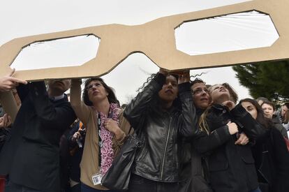 Un grupo se protege la vista con unas gafas especiales gigantes, en Francia.