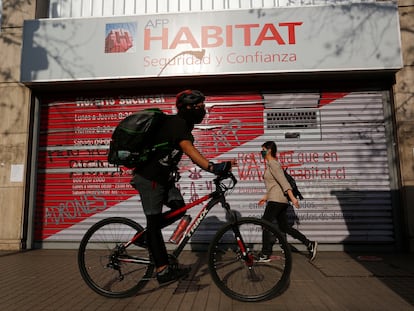 Dos personas pasan frente a una oficina de AFP (administradora de fondos de pensiones), el 8 de julio de 2020, en Santiago (Chile).