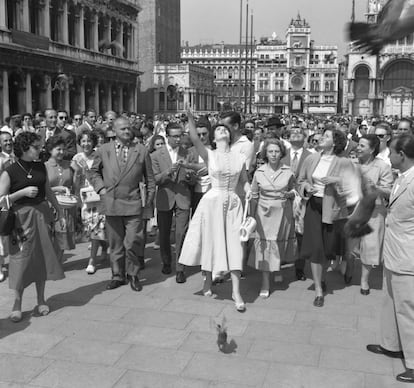 Gina Lollobrigida da de comer a las palomas de la plaza de San Marcos en Venecia mientras a ella la persiguen los fans. Italia pura. Era 1954.