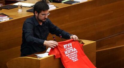 El diputado de EUPV Ignacio Blanco coloca en la tribuna la camiseta contra el cierre de RTVV.
